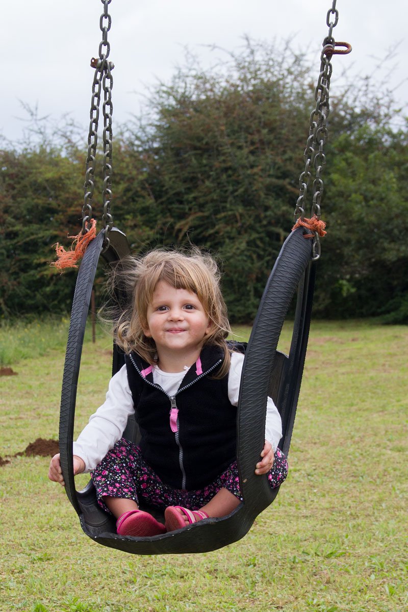 Emma enjoying the swings