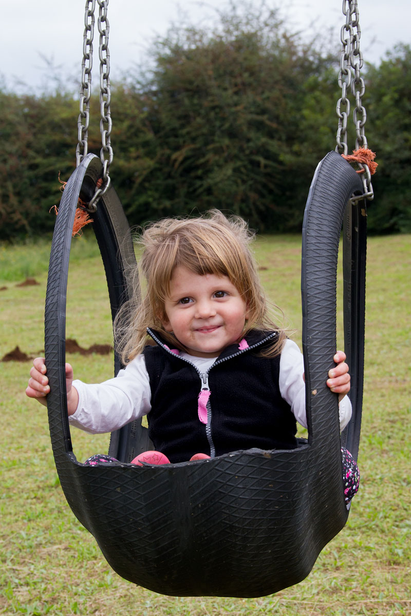 Emma enjoying the swings